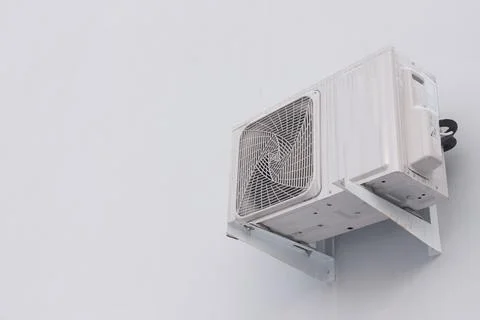 Outdoor air conditioner split system unit on white wall with copy space Stock Photos