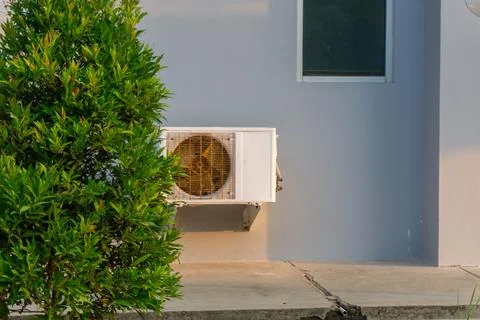 An outdoor air conditioning compressor unit mounted on a wall Foto stock