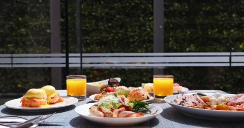 Outdoor breakfast spread featuring eggs Benedict, fresh salad, Stock Footage 318117443