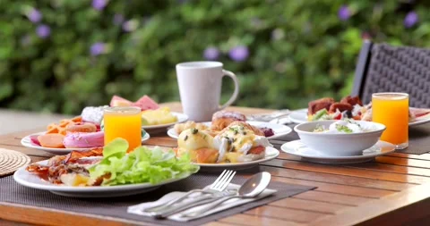 Outdoor brunch table with fresh breakfast dishes, juice, coffee set on Stock-Footage 312002692