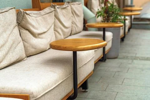 At the outdoor cafe, elegant sofas with small round wooden tables on single.. Stock Photos