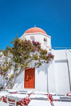 Outdoor cafe next to a classic chapel with a red dome in Mykonos. Stock Photos