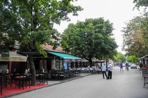Outdoor cafe seating along tree-lined street in Niksic, Montenegro Stock Photos