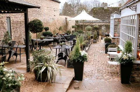 Outdoor cafe setting, with empty chairs and tables set up on a quiet terrace. Stock Photos