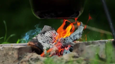 Outdoor campfire burning brightly with logs and red-orange flames, dark cooking Stock-Footage 339865626