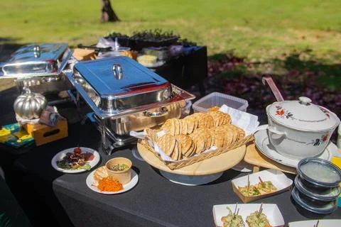 Outdoor catering buffet table with flatbread and chafing dishes Stockfoto's