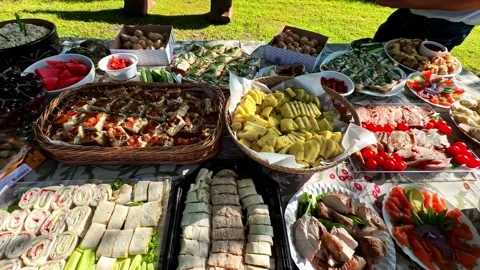 Outdoor catering buffet table with various delicious appetizers and traditional Stock Footage 341544746