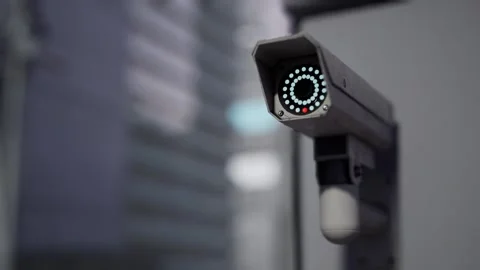 Outdoor CCTV Security Camera Mounted on Building Wall with Blurred City Video stock 331574329