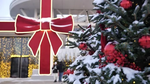Outdoor Christmas tree decorations with red ornaments and snow in urban setting Stock Footage 339493913