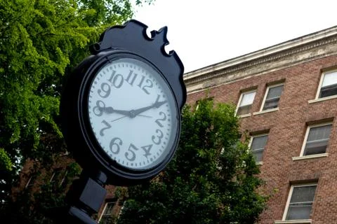 Outdoor clock in front of a brick wall Stock Photos