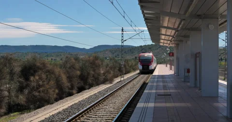 Outdoor commuter train makes entry into empty station Stock Footage 216539250