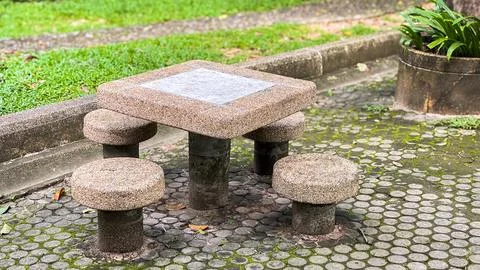 Outdoor concrete table with round stools for relaxing in the park. Stock Photos