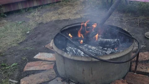 Outdoor cooking fire pit with burning logs and smoke Stock Footage 337105387