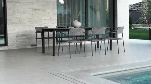 Outdoor dining area by the pool with a large dining table and plenty Stock Footage 220773495