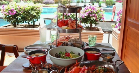 Outdoor dining setting with seafood platter, salads by pool, Stock-Footage 318120523
