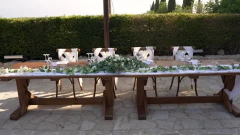 Outdoor dining setup with elegant decor and greenery in a lovely garden space Stock Footage 323179160