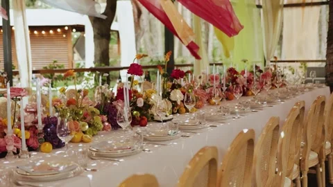 Outdoor dining table beautifully decorated with bright flowers and elegant Stock Footage 324677121
