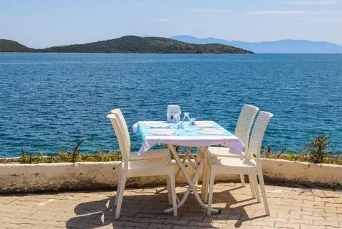 Outdoor dining table overlooking the Aegean sea with islands in the backgro.. Stock Photos