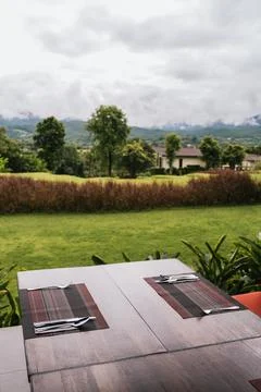 Outdoor dining table set overlooking green countryside and mountains Stock-Fotos