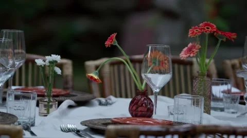 Outdoor Dinner Table Set With Orange Gerbera Daisies in Bud Vases Stock Footage 347913235