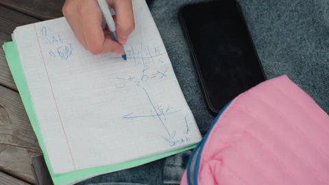 Outdoor educational setting with student drawing math doodles. Teenager Stock Footage 329888196