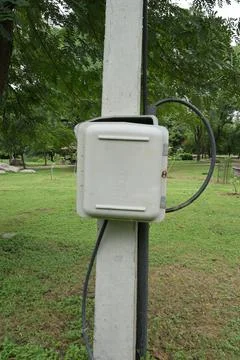 Outdoor electrical junction box mounted on utility pole in public park envi.. Stock Photos