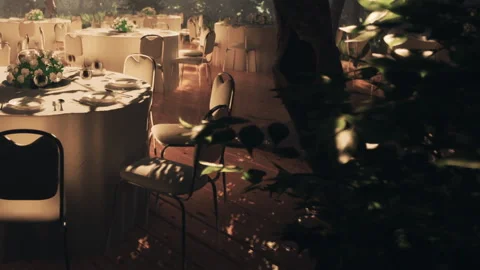Outdoor event setting with tables and chairs surrounded by nature Stock Footage 345046037