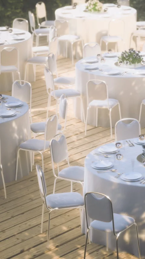 Outdoor event setup with tables and chairs ready for guests in daylight Stock Footage 336572512