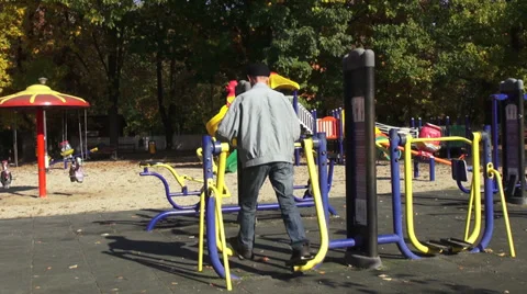 Outdoor exercise, old man working on fitness equipment in the park Stock Footage 32153136