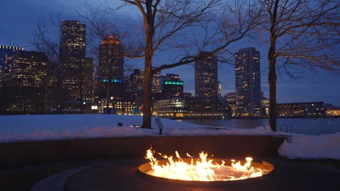 Outdoor fire pit burning bright on a winter night at Boston Fan Pier Park Stock Footage 303487781