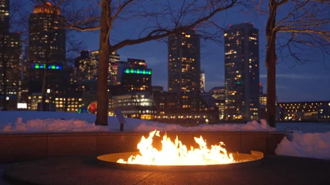 Outdoor fire pit burning bright on a winter night at Boston Fan Pier Park Stock Footage 303487784