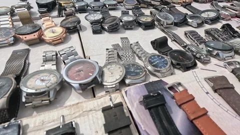 Outdoor flea market display of assorted used wristwatches arranged on cardboard Stock Footage 346158998