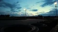 Outdoor go-kart track with cars passing under dark blue evening sky, time-lapse HD Footage