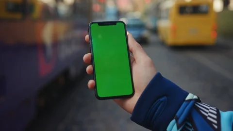 Outdoor hand using phone with vertical green screen background traffic car city Stock Footage 117951032