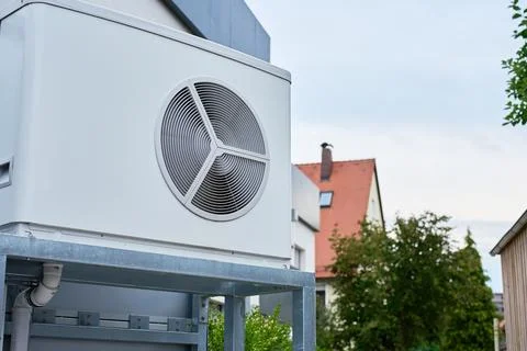 Outdoor heat pump unit installed next to residential building Stock Photos