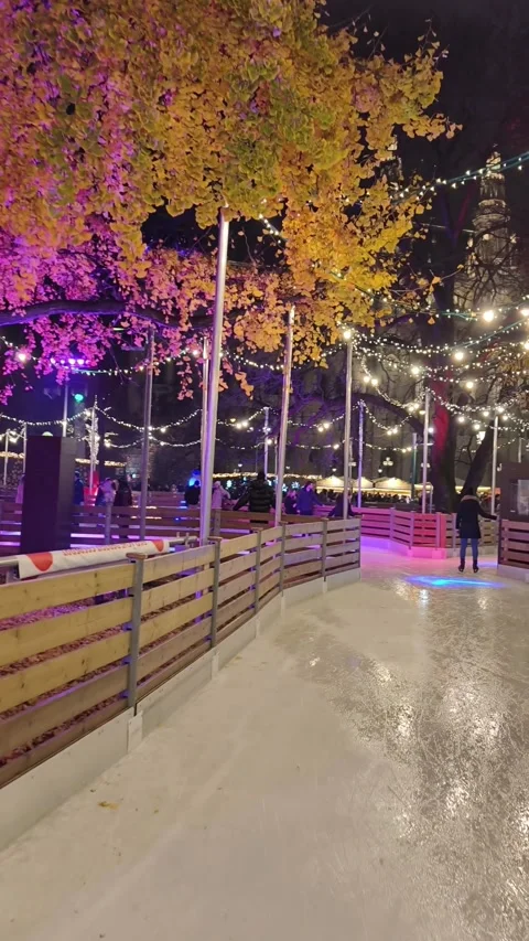 Outdoor ice skating path at a Christmas market in Vienna. skaters gliding along Stock Footage 323505255