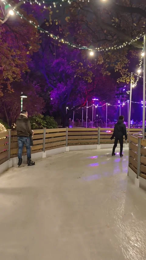 Outdoor ice skating path at a Christmas market in Vienna. skaters gliding along Stock Footage 323505962