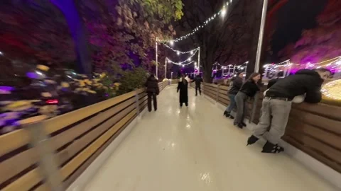 Outdoor ice skating path at a Christmas market in Vienna. skaters gliding along Stock Footage 323507331