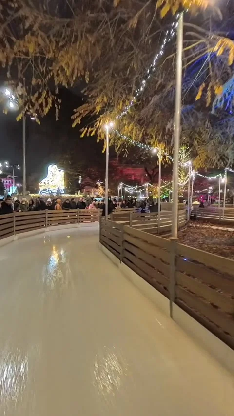 Outdoor ice skating path at a Christmas market in Vienna. skaters gliding along Stock Footage 323508101