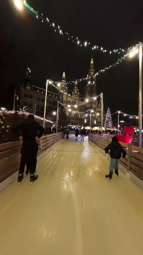 Outdoor ice skating path at a Christmas market in Vienna. skaters gliding along Stock Footage 323508190