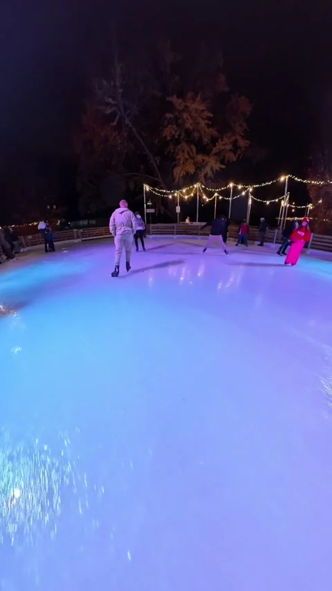 Outdoor ice skating path at a Christmas market in Vienna. skaters gliding along Stock Footage 323508315