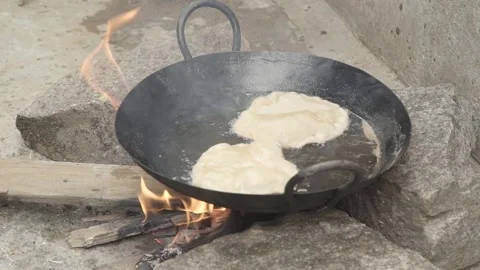 Outdoor Indian kitchen cooking flatbread over wood burning fire. Chapati Naan Video stock 131339169