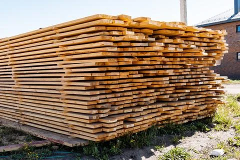 In an outdoor industrial yard, a large stack of neatly arranged cut lumber .. Foto stock