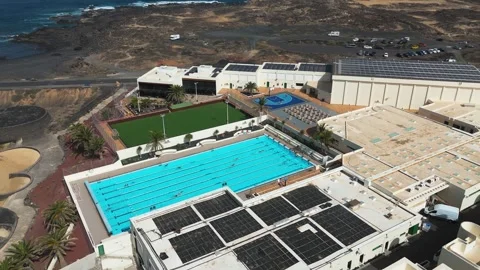Outdoor Lap Pool and Green Sports Field Surrounded by Resort Buildings Stock Footage 344022591