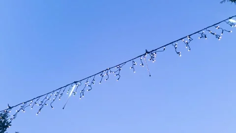 Outdoor LED string lights. Electric string lights, bulbs against the backdrop Vidéo 347670678