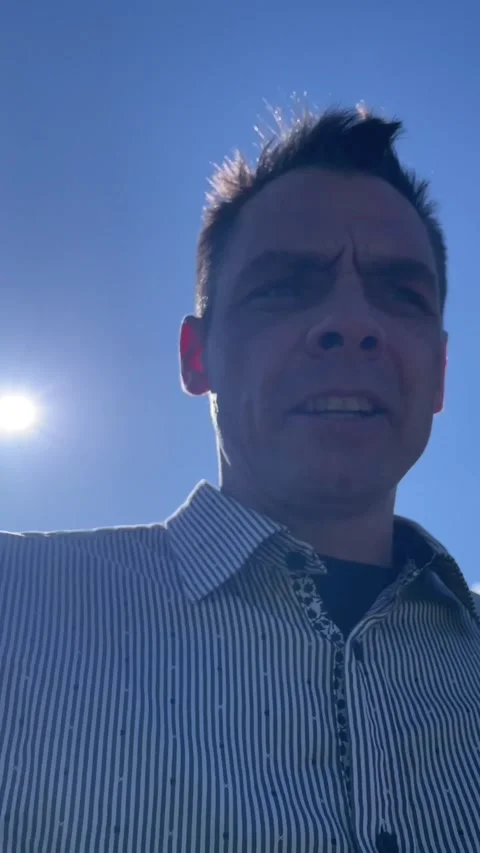 Outdoor low-angle close up of middle-aged man squinting in bright sunlight Stock Footage 341672631