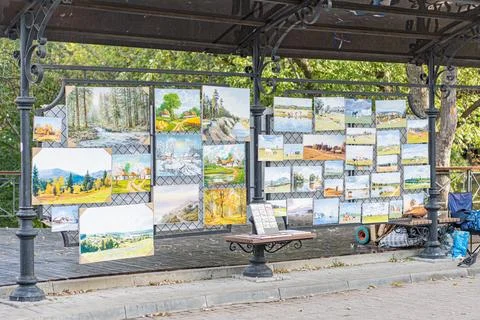 Outdoor makeshift gallery displaying assorted photographs of landscapes, city Stock Photos