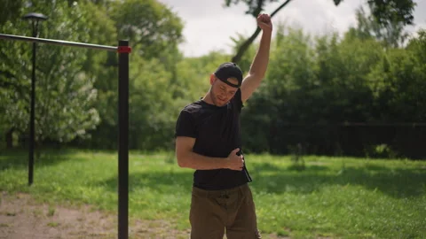 Outdoor Man Performing Dynamic Torso And Arm Swings Near Pullup Bars, Active Stock Footage 324754179