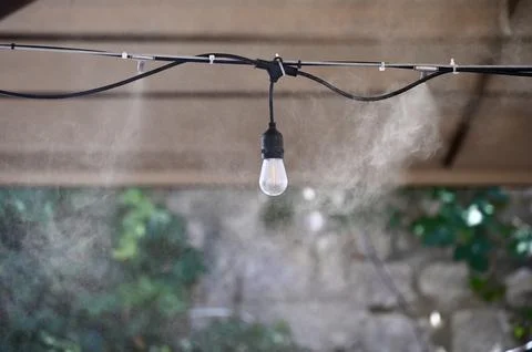 Outdoor Misting System and String Light Bulb Cooling Outdoor Cafe Patio Stock-Fotos