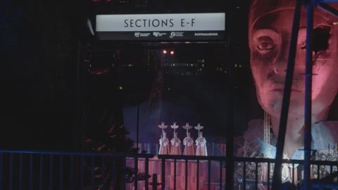Outdoor Night Stage Performance With Costumed Figures and Large Head Sculpture Stock Footage 345717632